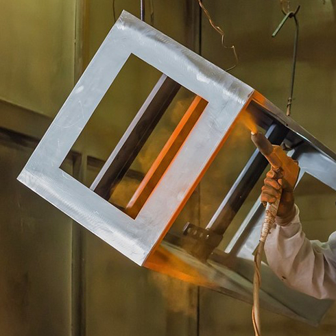 Painting a bespoke metalwork frame using an airbrush.