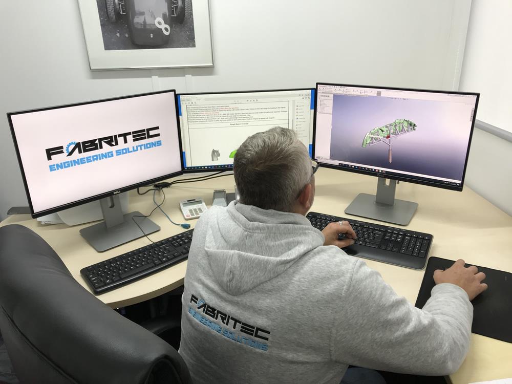 A member of the Fabritec design team using CAD software on a computer to design a bespoke assembly part.