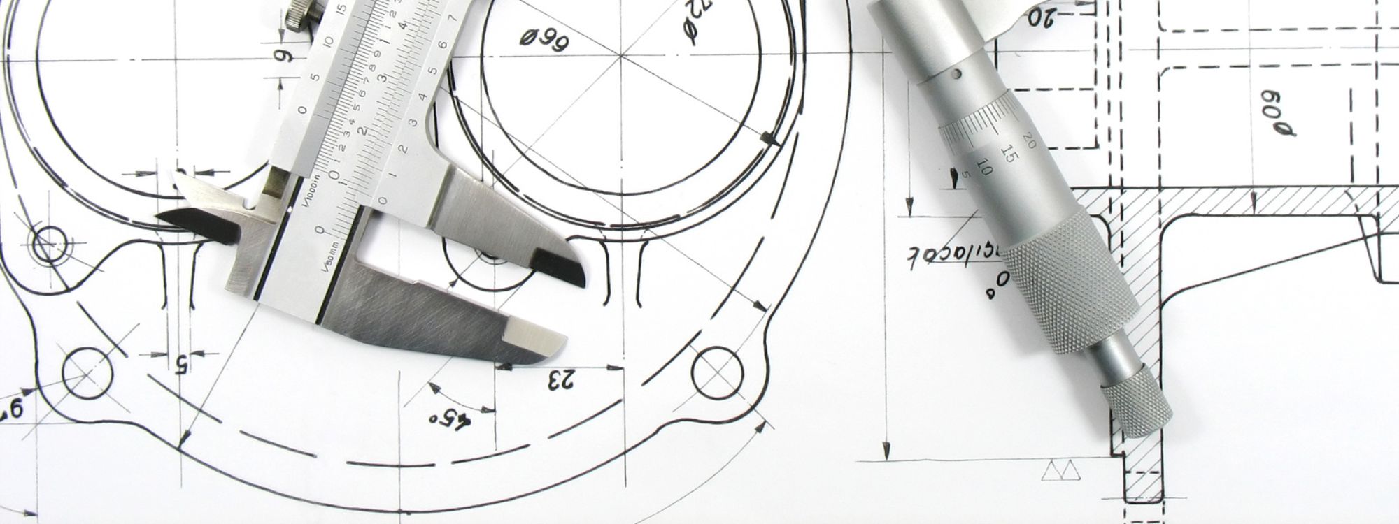 Engineering drawing with a vernier and other measuring tools sitting on top